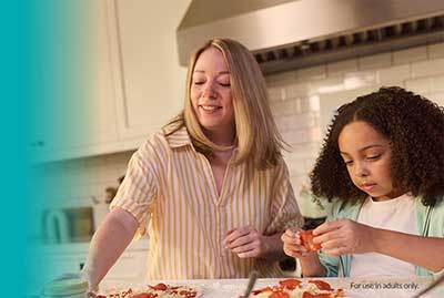 Adult and child preparing food together at a kitchen counter